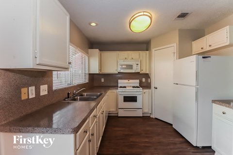 a kitchen with white appliances and white cabinets