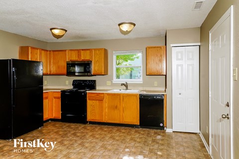 A kitchen with wooden cabinets and black appliances.