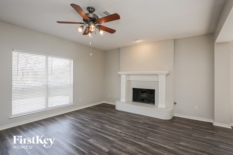 a living room with a fireplace and a ceiling fan