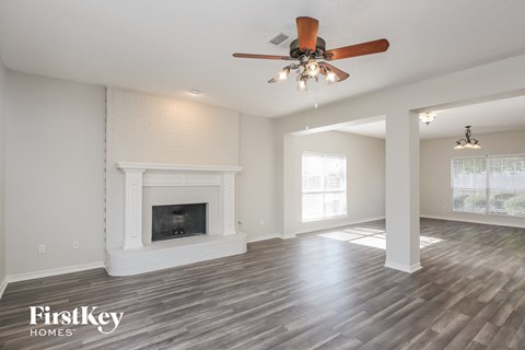 the living room with fireplace and ceiling fan