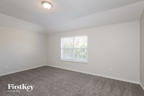 a bedroom with a carpeted floor and a window