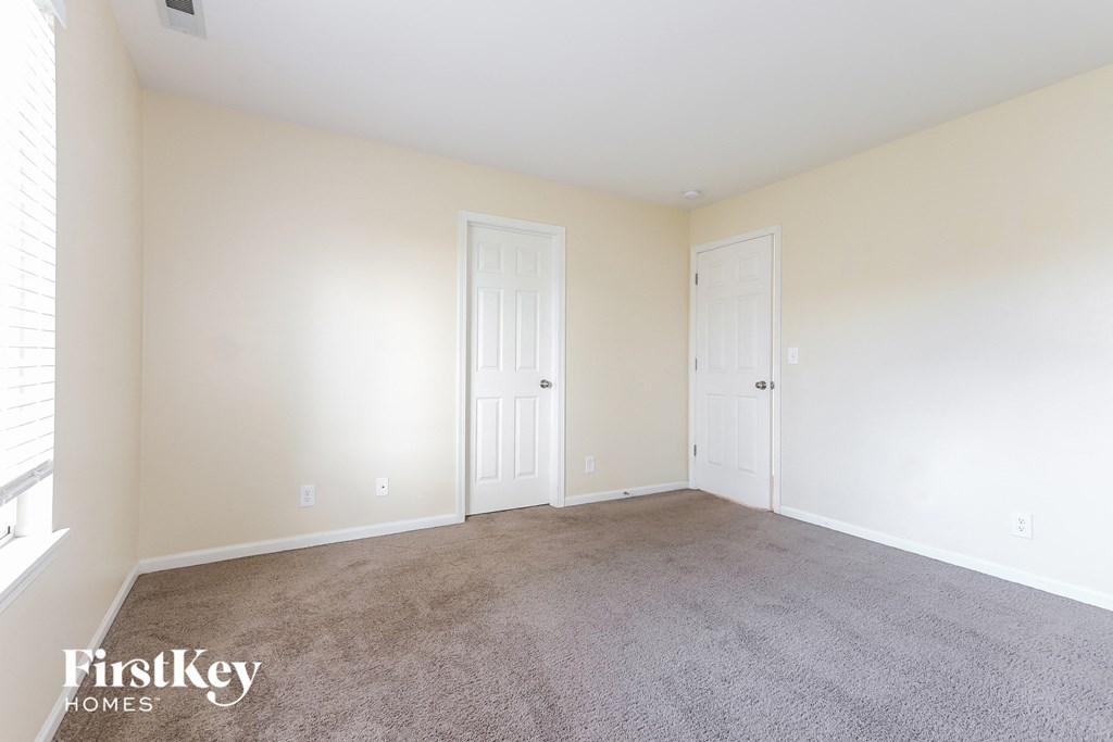 a living room with carpet and two doors