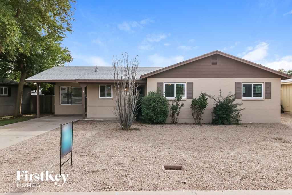 a small house with a gravel yard and a driveway