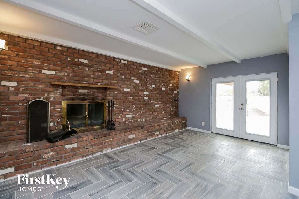 the living room of a house with a brick fireplace