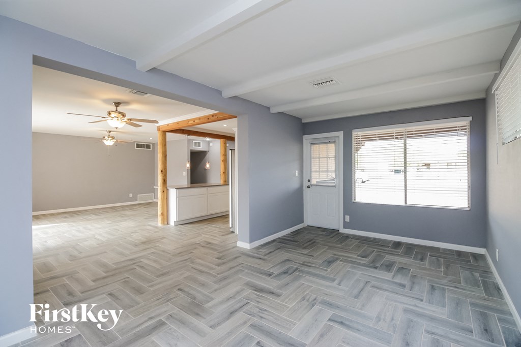 the living room and entryway of a house with a checkered wood floor