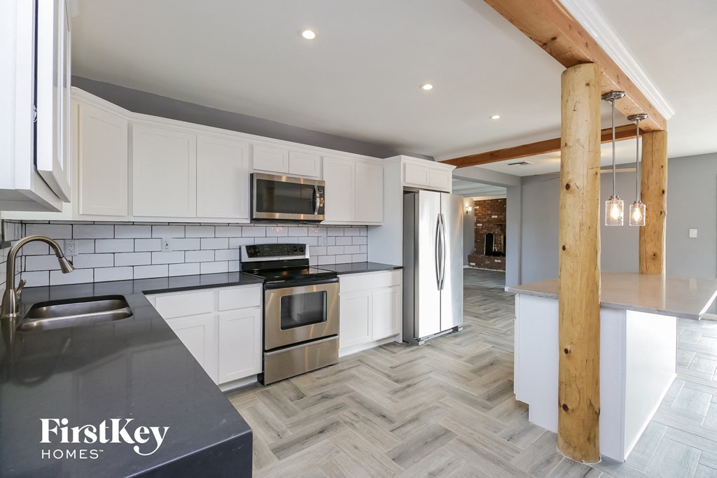 a modern kitchen with white cabinets and stainless steel appliances