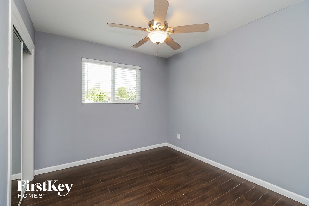 a bedroom with a ceiling fan and a window