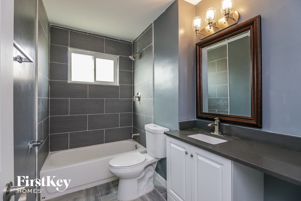 a bathroom with a toilet and a sink and a bath tub