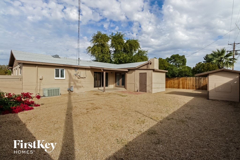 a beige house with a yard and a fence
