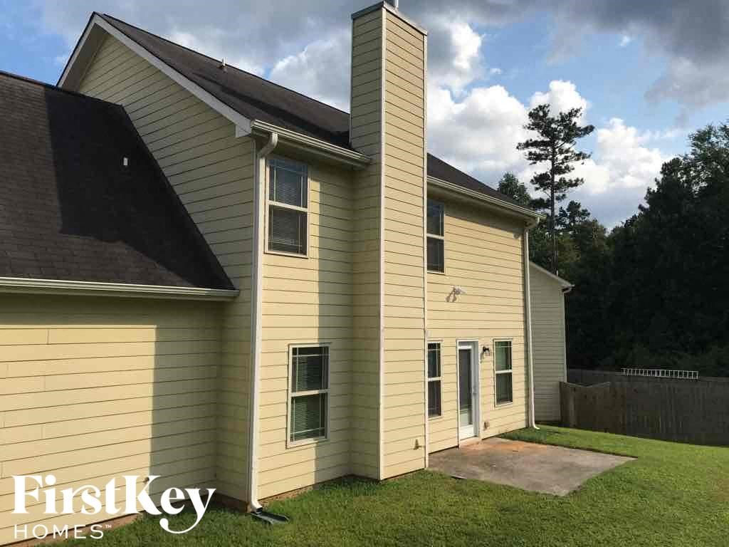 a yellow house with a chimney on the side of it