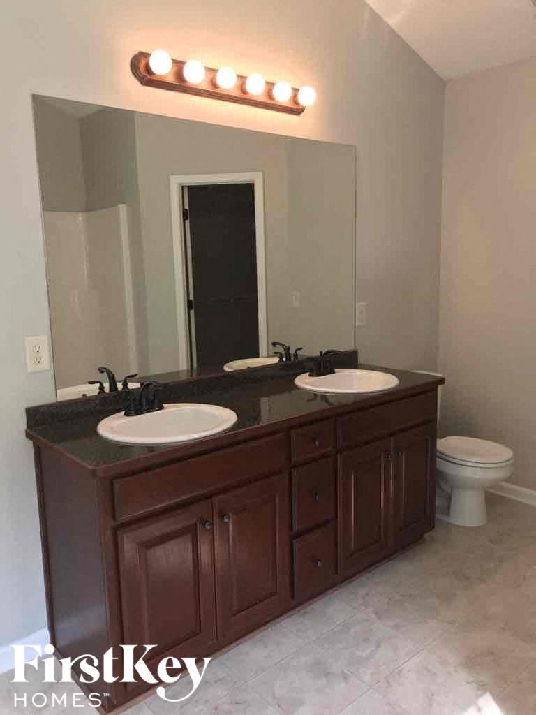 a bathroom with two sinks and a mirror and a toilet