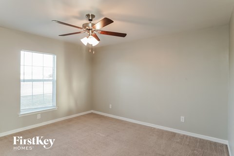a bedroom with a ceiling fan and a window