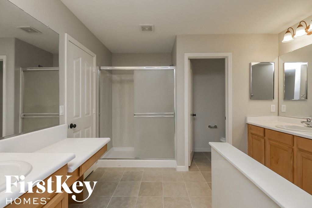 a large bathroom with two sinks and a shower and a tub