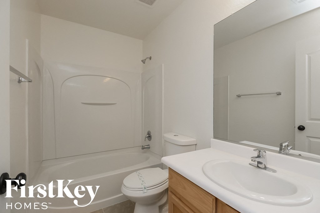 a white bathroom with a white sink and a toilet and a bath tub