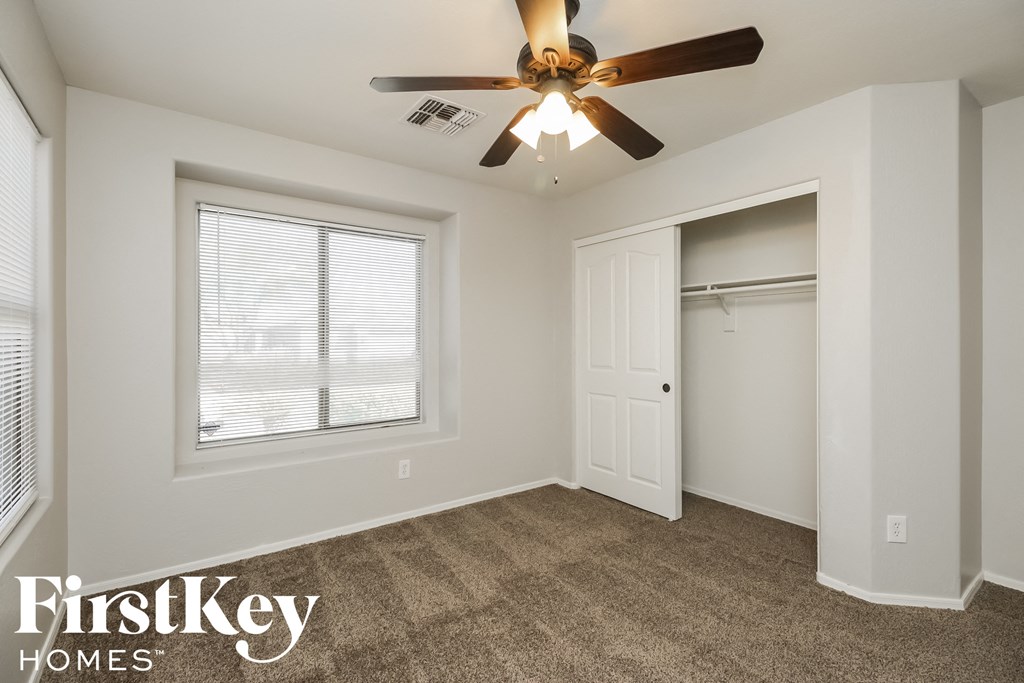 a bedroom with a ceiling fan and a closet