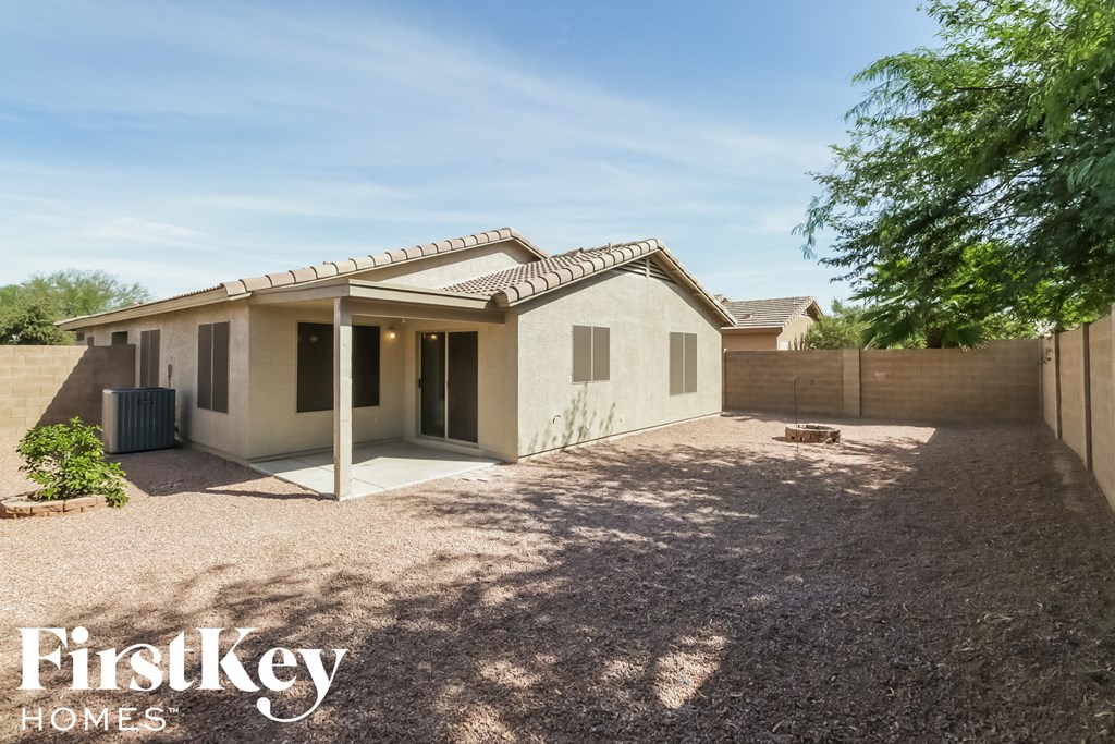 a small house with a gravel driveway and a tree