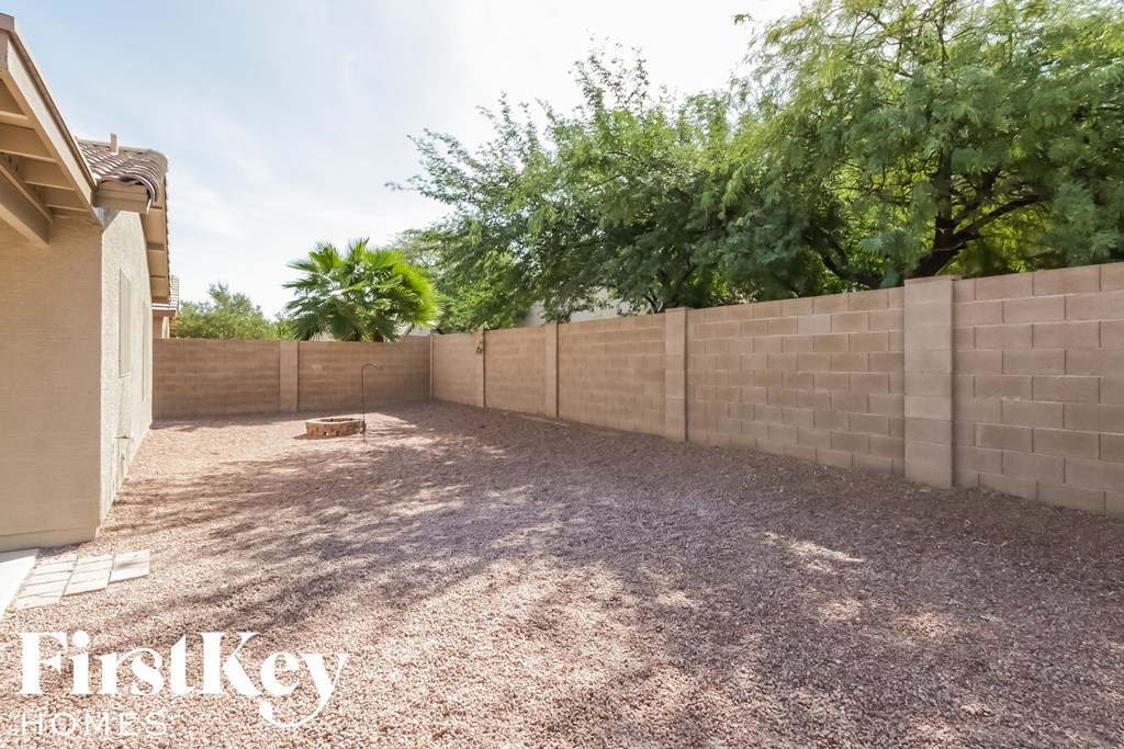 a backyard with a retaining wall and a tree