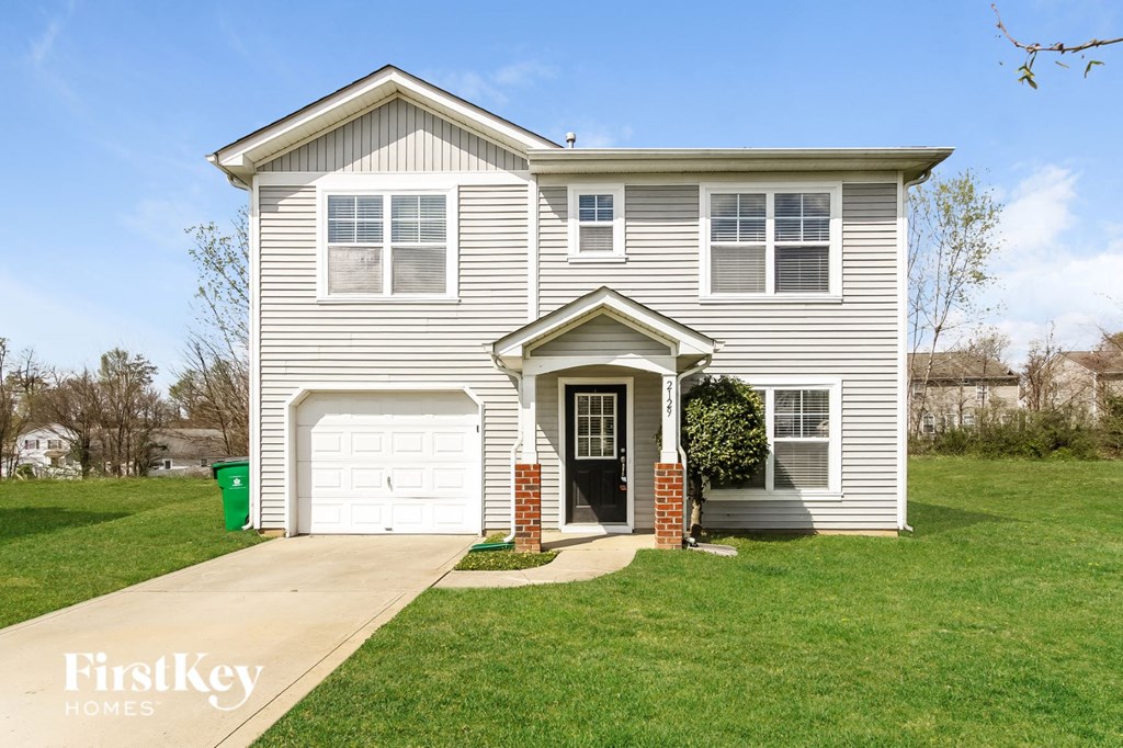 A house with a garage and a driveway in front.