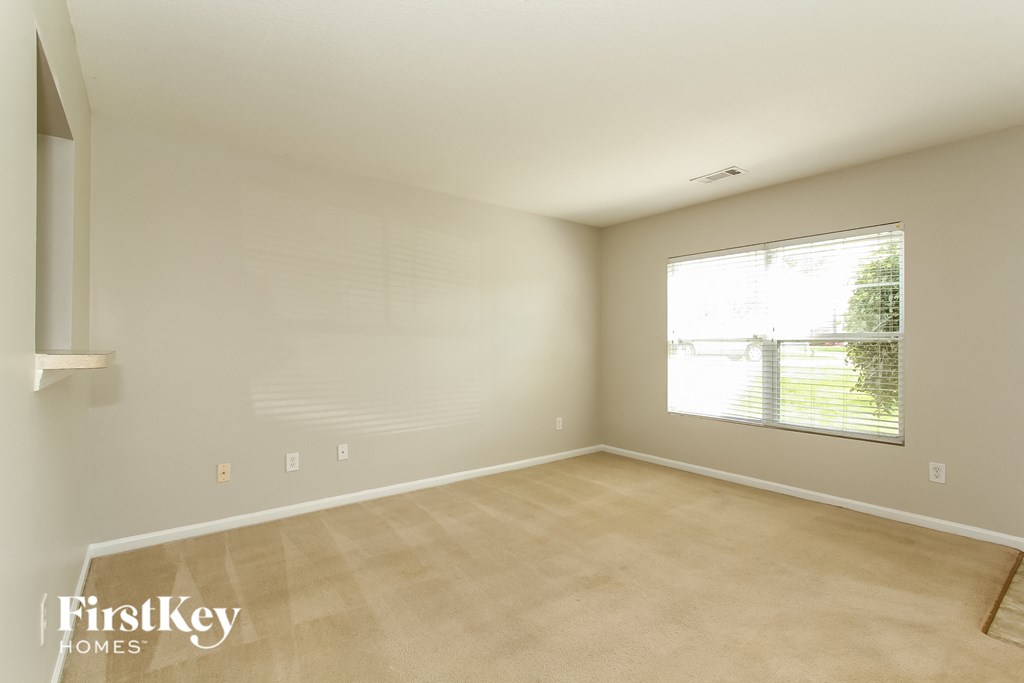 A room with a window and a wooden floor.