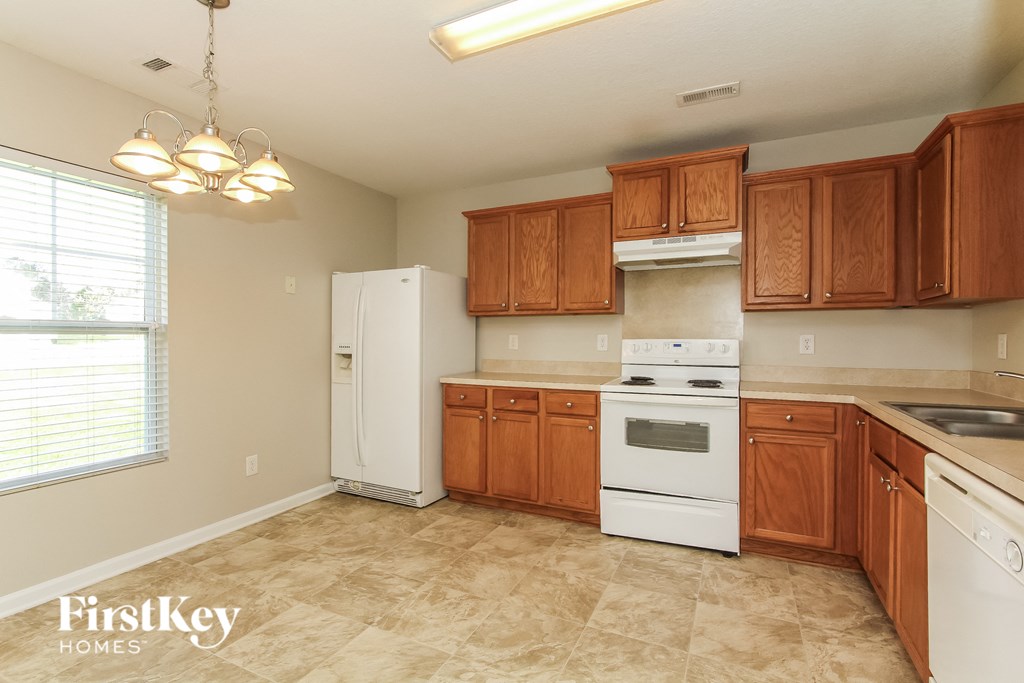 A kitchen with wooden cabinets and a white refrigerator.