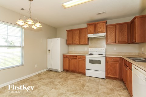 A kitchen with wooden cabinets and a white refrigerator.