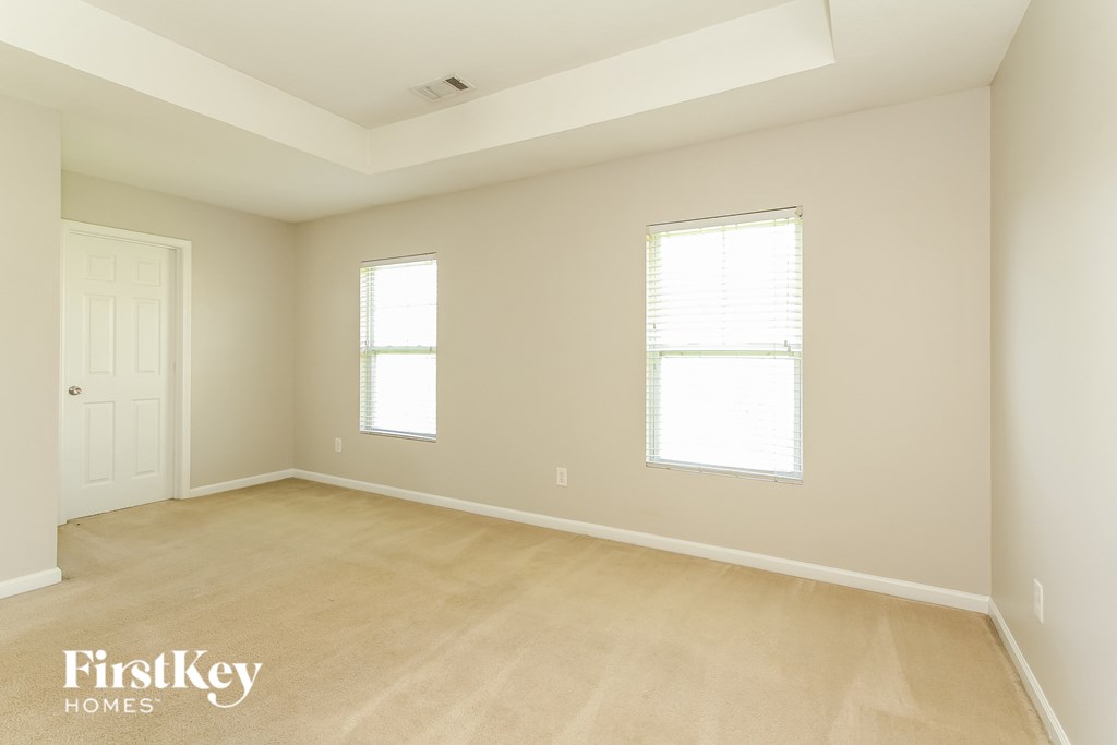 A spacious room with two windows and a door.