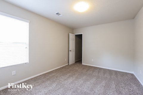 a spacious room with carpeted flooring and a large window