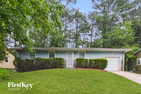a blue house with a yard and a white garage door