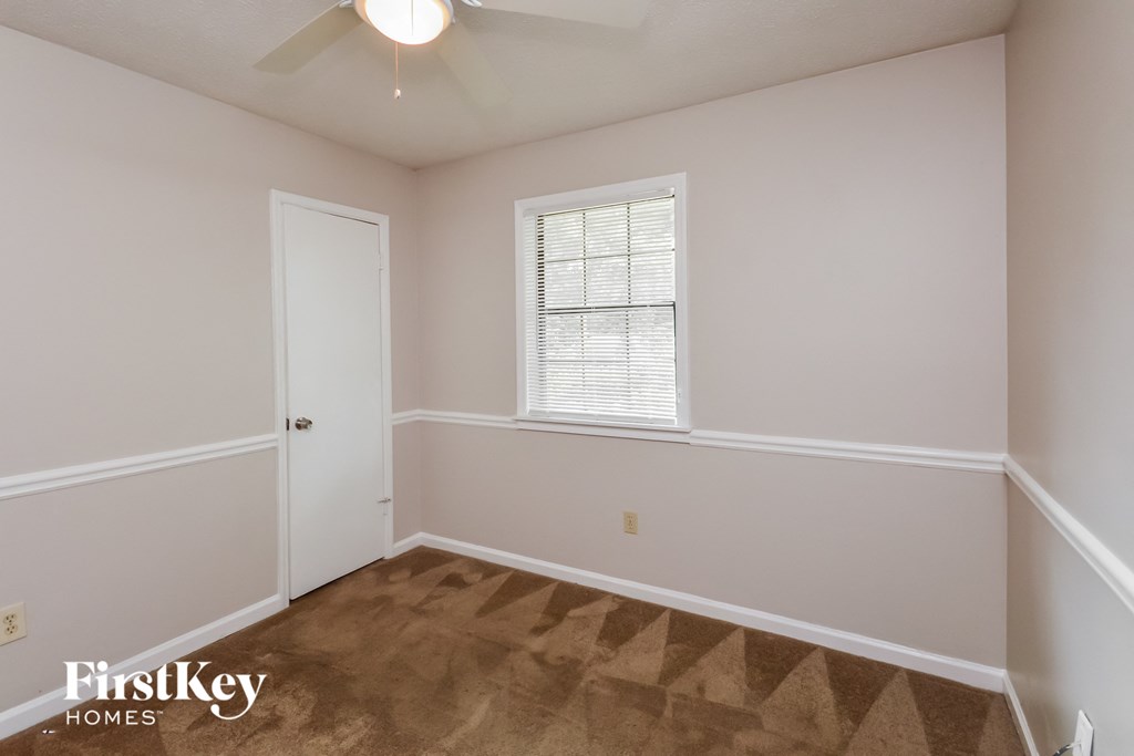 a bedroom with white walls and a white door and a window