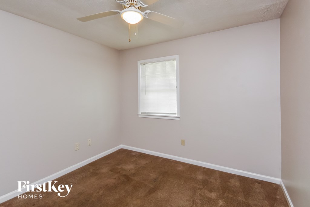 the upstairs bedroom with carpet and a ceiling fan