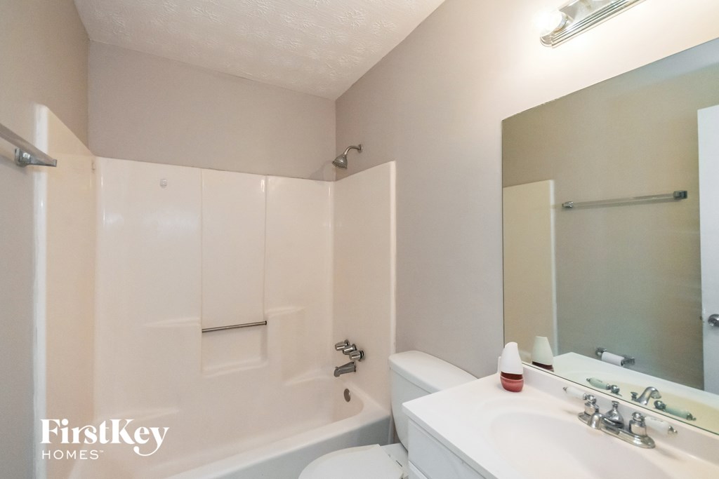 a bathroom with a sink and a tub and a mirror