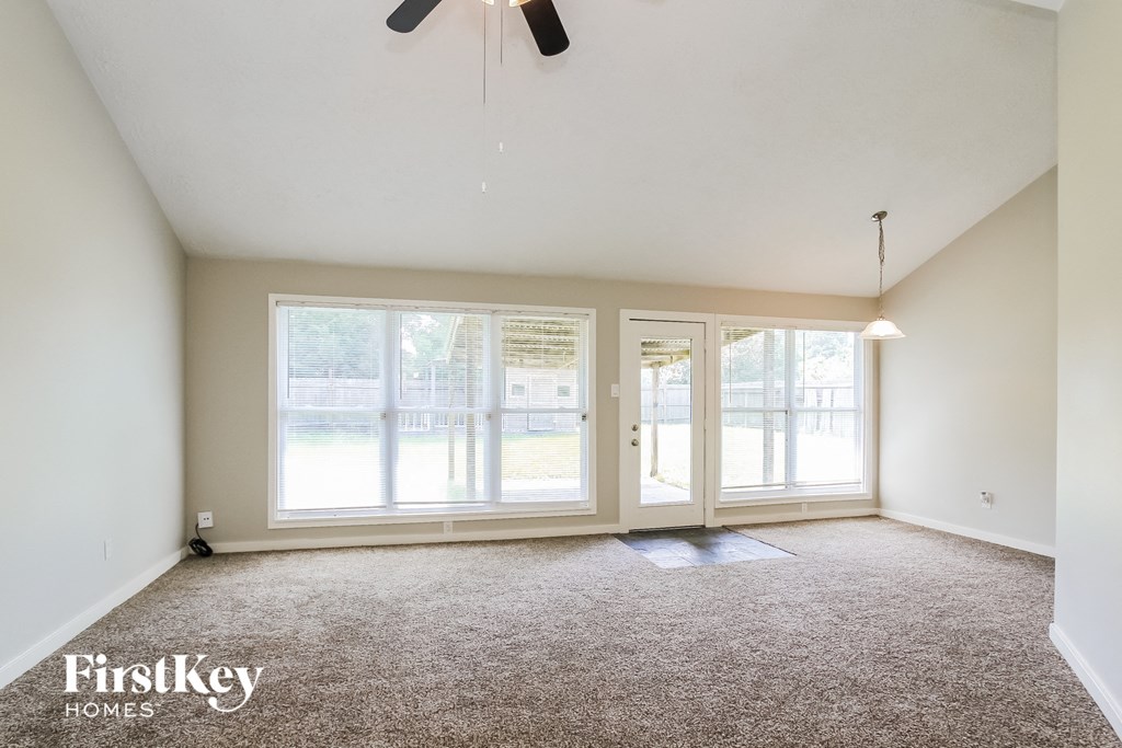 the living room of an empty house with large windows