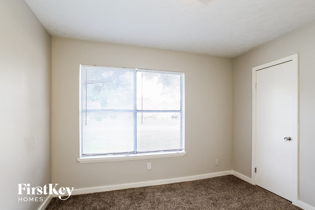 a bedroom with a large window and a door