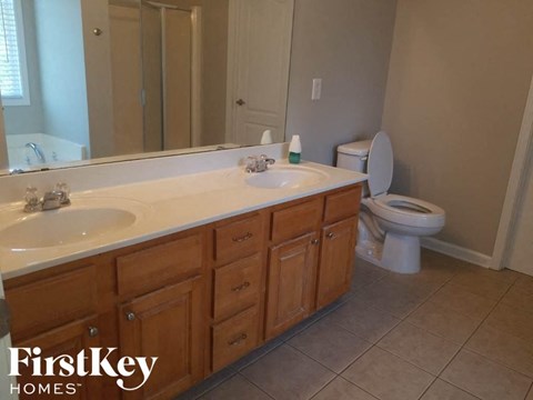 A bathroom with a white toilet and wooden cabinets.
