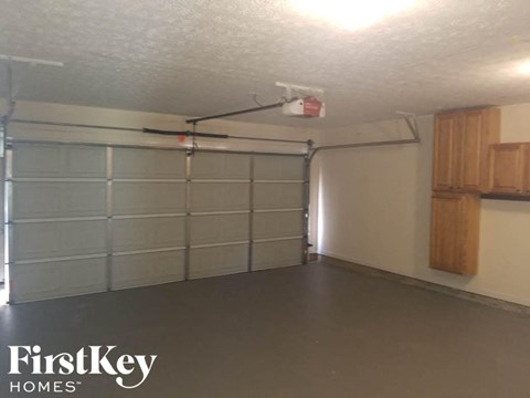 A spacious garage with a FirstKey Homes logo on the wall.