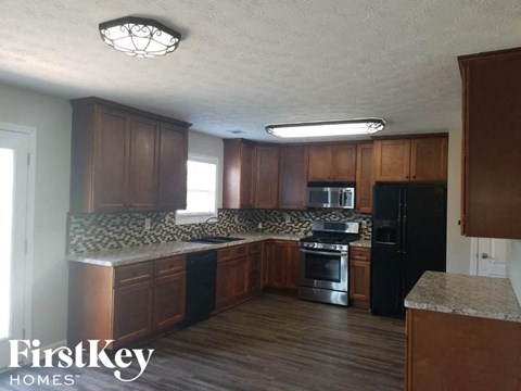 A kitchen with wooden cabinets and black appliances.