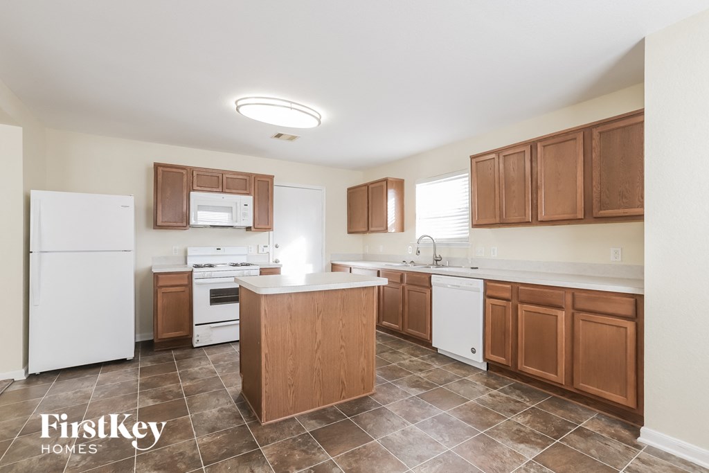 a kitchen with white appliances and wooden cabinets