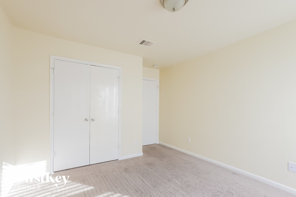 a bedroom with a carpeted floor and a closet