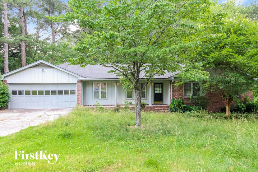 a small white house with a tree in front of it