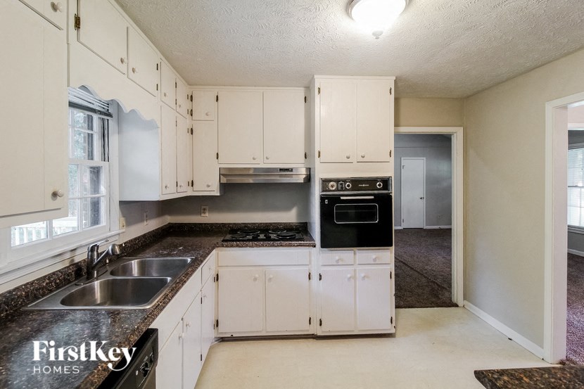 a kitchen with white cabinets and black counter tops