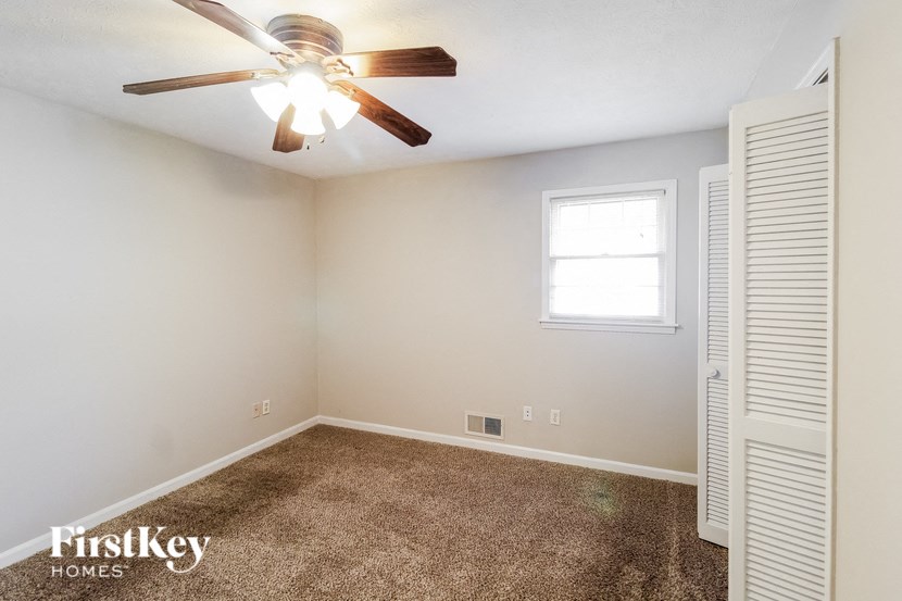 a bedroom with a ceiling fan and a window
