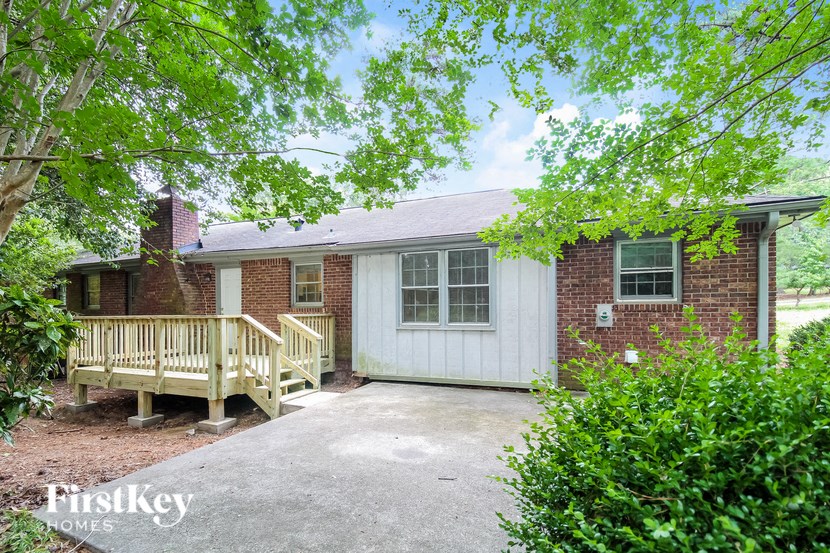 a small brick house with a porch and a deck