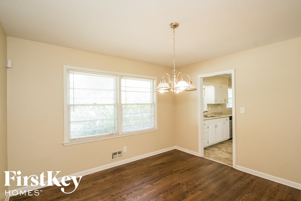 a kitchen and dining room with wood flooring and a large window