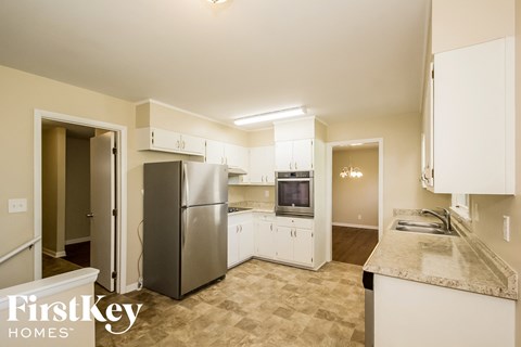 a kitchen with white cabinets and a stainless steel refrigerator