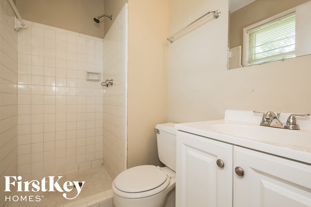 a white bathroom with a toilet and a sink