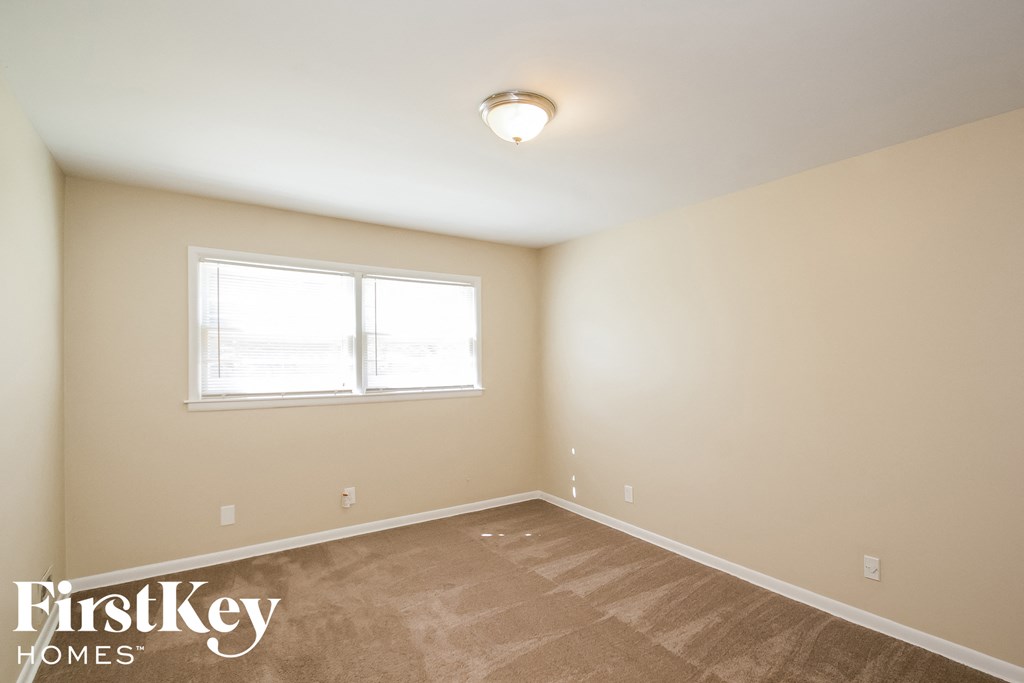 a bedroom with a carpeted floor and a window