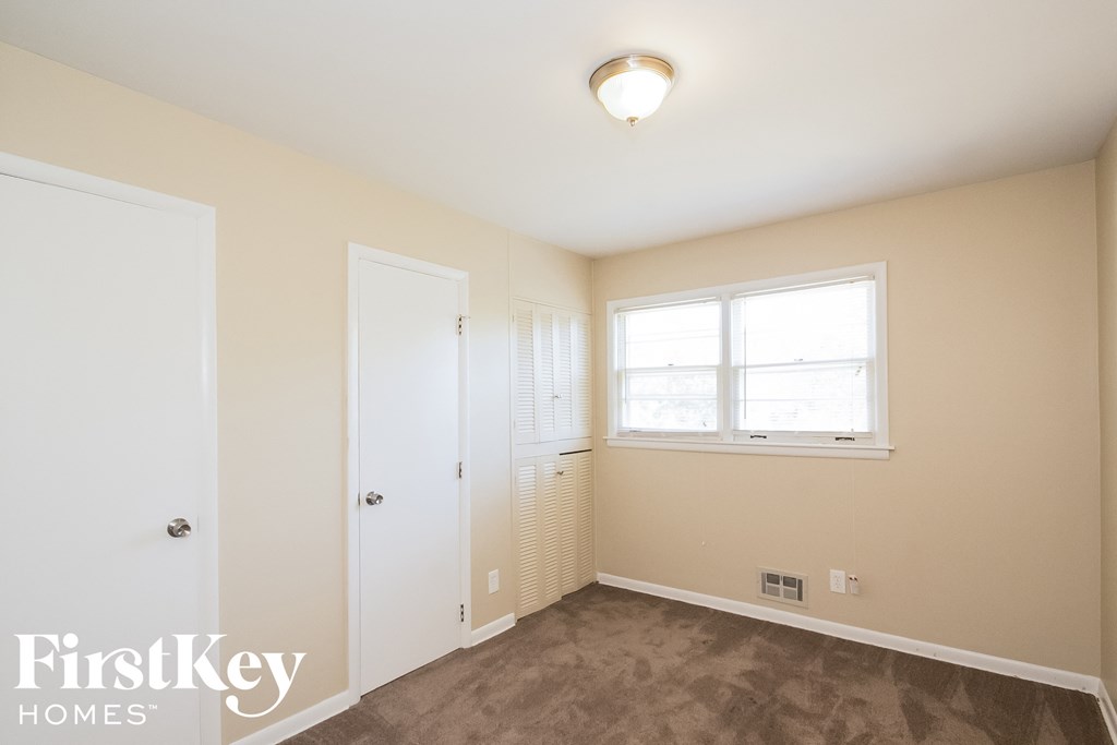 a bedroom with a closet and a window and a door