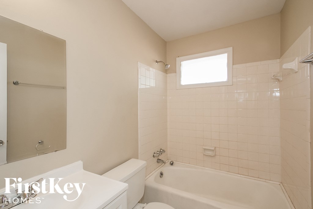 a white bathroom with a tub and a toilet and a sink