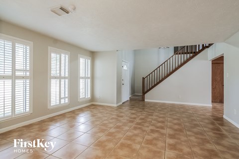A spacious room with a staircase and tiled flooring.