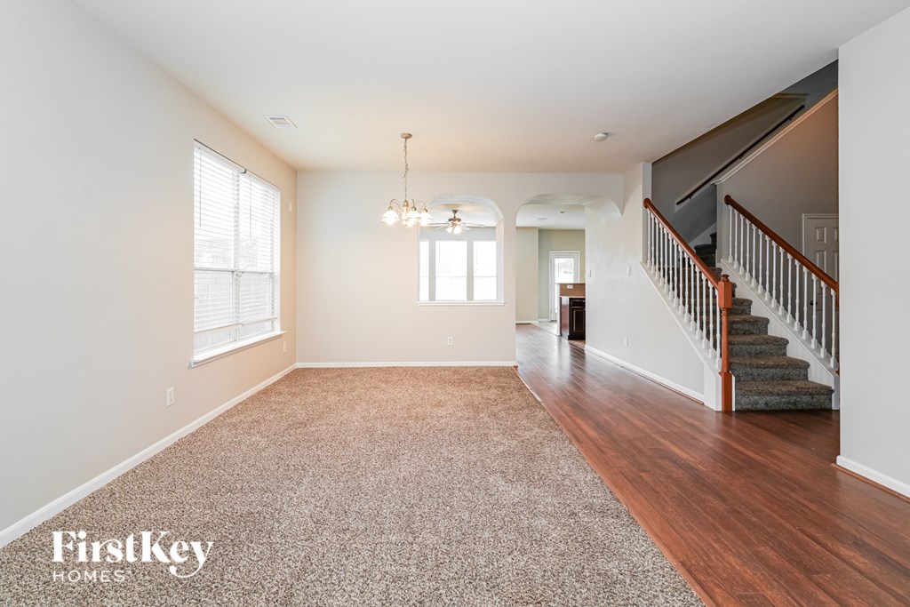 A spacious room with a staircase leading to the upper floor.